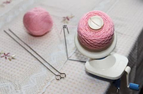 Process of winding pink wool yarn from tangle to winding, using a coiler Foto stock