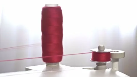 The process of winding red thread on the bobbin of a modern sewing machine Stock Footage 234539174