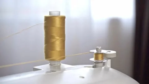 The process of winding yellow thread on the bobbin of a modern sewing machine Stock Footage 234207295