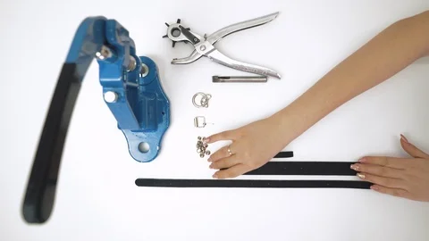 Process of working with a leather product. Use the tool for perforation Stock Footage 105094141