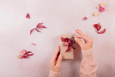 Process of wrapping and decorating presents with dried flowers Stock Photos