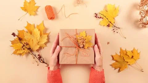 Process of wrapping and decorating presents with dried leaves 写真素材
