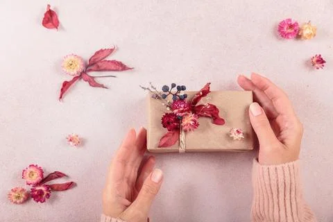 Process of wrapping and decorating presents with dried flowers Stock Photos