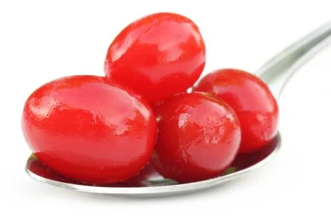 Processed cherry on a silver spoon Stock Photos