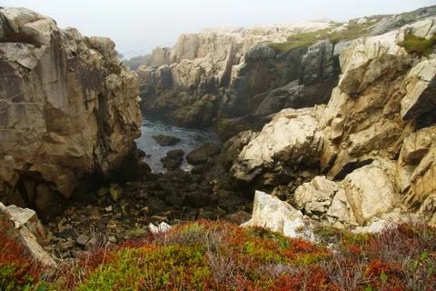 Processed by: Helicon Filter; Tiny bay surrounded by light and dark rocks wit Stock Photos