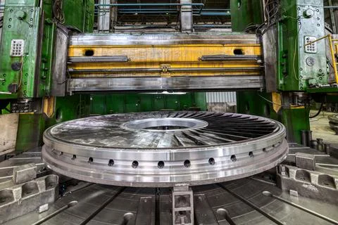 Processed part with vertical turning lathe machine in shop Stock Photos