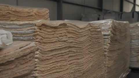 Processed rubber sheets stacked inside industrial recycling facility Stock Footage 322219782