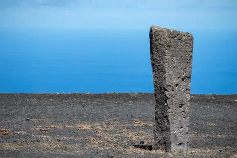 Processed stone column against the blue sky and ocean Stock Photos