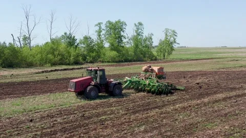 Processing farmland with a cultivator. Cleaning beets with a combine harvester Stock Footage 154346011