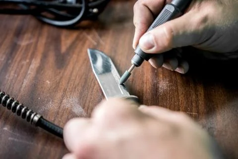 Processing of the knife blade with special equipment to make it very sharp Stock Photos