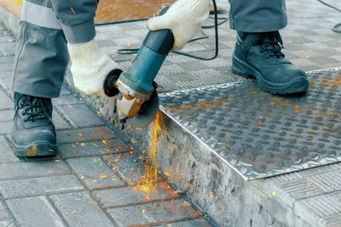 Processing of metal sheet with an angle-grinding tool Stock Photos