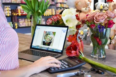 Processing orders on a laptop. Small floral business. Salon of flowers and gifts Stock Photos