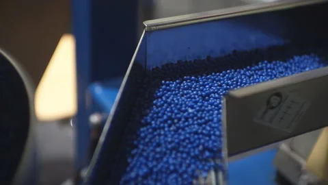 Processing of polymeric materials. Moving blue granules in production. Technolog Stock-Footage 124407688