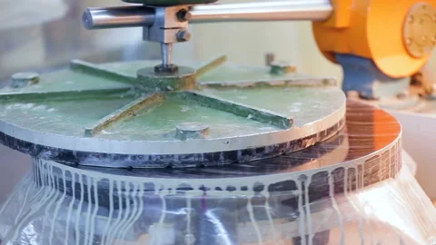 Processing the product on a grinding machine with a white liquid to give it Stock Footage 92254863