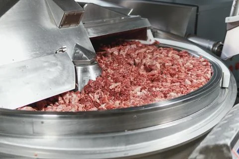 Processing of production minced meat in industrial meat grinder, close up. Stock-Fotos