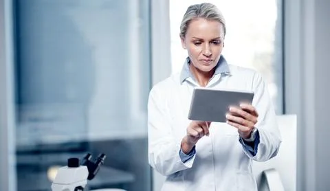 Processing scientific data on her device. a mature scientist using a digital Stock Photos