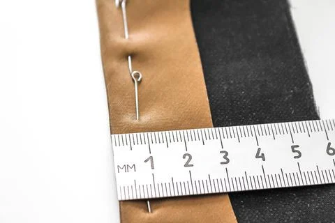 Processing of the seam with an oblique brown silk label. Close-up, wrong side. Stock Photos