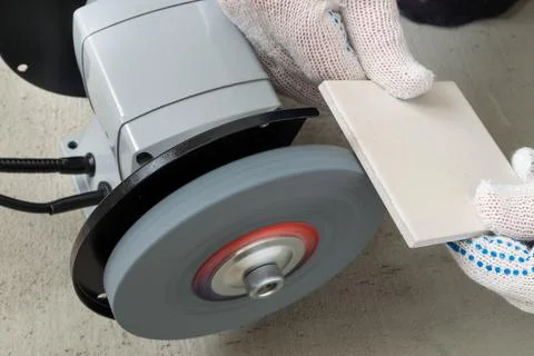 Processing tile or porcelain tiles with a grinder. Stock Photos