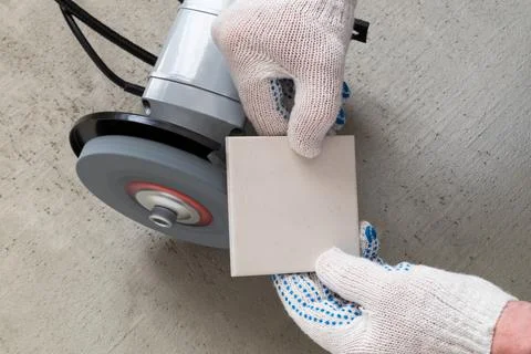Processing tile or porcelain tiles with a grinder. Stock Photos