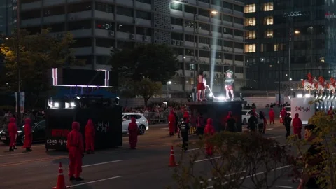 A procession of 'Squid Game' themed parade floats, including a Netflix float Stock Footage 312319916