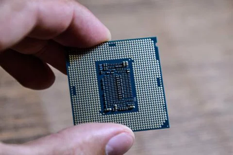 The processor is a desktop computer in hand. Inspect the CPU contacts before Stock Photos