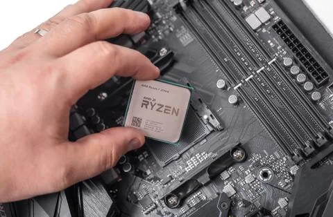 Processor Ryzen 7 2700X in hand against the background of a computer motherboard 写真素材