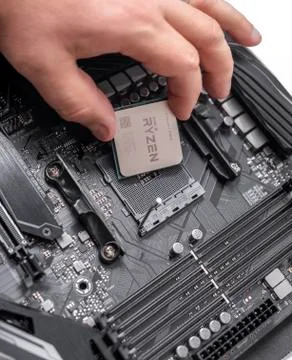Processor Ryzen 7 2700X in hand against the background of a computer motherboard 写真素材