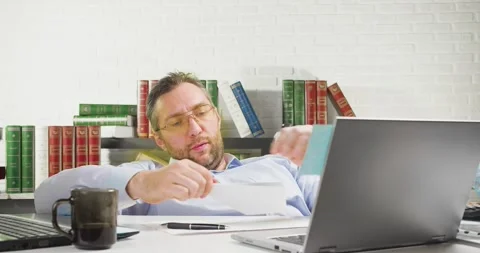 Procrastination concept - middle-aged man is lounging in the office, he makes a Stock Footage 169407150