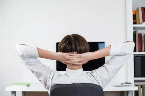 Procrastination concept: office worker stretching in front of black computer  Stock Photos