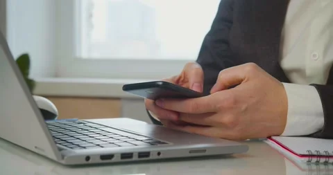 Procrastination - Female hands with a smartphone in front of a laptop monitor. A Stock Footage 171106555