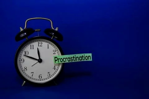 Procrastination write on sticky note isolated blue background. Delay Concept Stock Photos