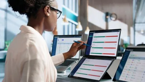Procurement Manager Analyzes Vendor Data On Dual Touchscreen Laptop Carefully Stock Photos