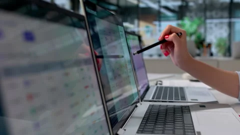 Procurement Manager Using Multiple Computer Screens Analyzing Supplier Data Stock Footage 339898798