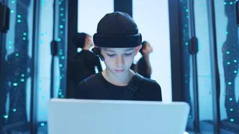 Prodigy boy hacker programming code on laptop turning power off at server room Stock Footage 120697471