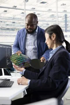 Producing integrated circuits, silicon wafer materials and engineers Stock Photos
