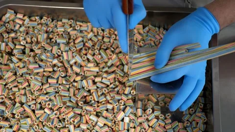 Production of caramel candies, the master cuts caramel candies with a spatula. Stock Footage 330870176