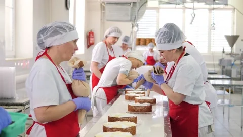 Production of confectionery products.The process of decorating cakes on an Stock Footage 171893689