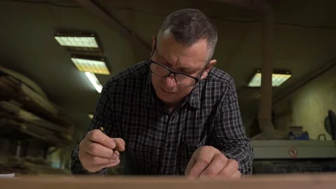 Production engineer fills out technical documentation at the table with a pencil Stock Footage 149308005