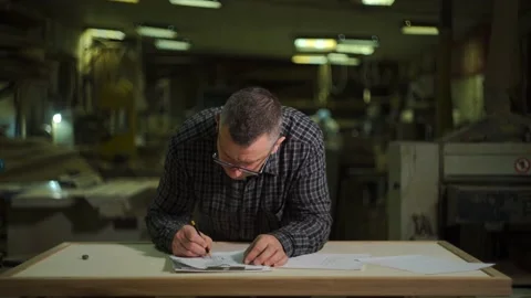 Production engineer fills out technical documentation at the table with a pencil Stock Footage 149312036