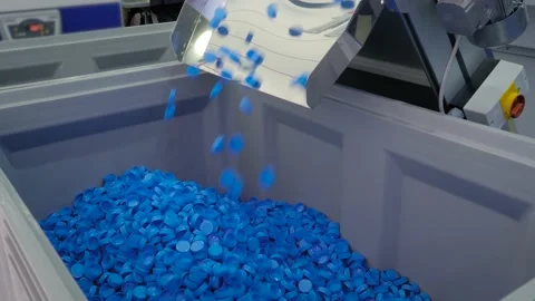 Production line - many blue plastic bottle caps falling from conveyor belt Stock Footage 156380863