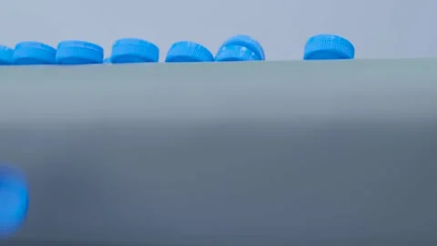 Production line - many blue plastic bottle caps falling from conveyor belt Vidéo 168617536