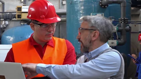 Production Manager Using Laptop and Talking to Worker in Protective Workwear Stock Footage 250180939