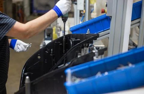 Production operator assembling frontlight headlamp, headlight for a vehicle or a Stock Photos