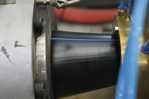 PRODUCTION OF PLASTIC DOUBLE LAYER pipe from polypropylene for water supply. Stock Photos