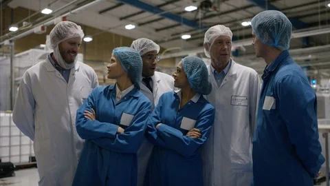 Production team smiling at camera in factory Video stock 107998914