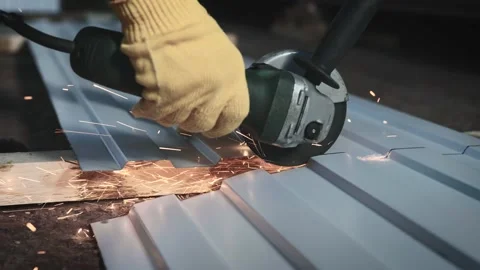 Production worker. A man cuts a sheet of metal with a grinder Stock Footage 171212838