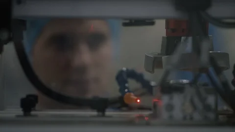Production worker observing cosmetic boxes on production line through glass Stock Footage 107995905