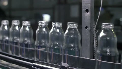 Production worker pulls out one of the bottles from the line at glass factory Stock Footage 149971371