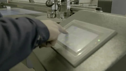 A production worker sets up a modern machine with a touchpad. Stock Footage 127038667