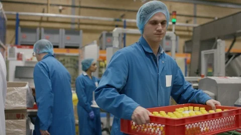 Production workers checking bottles and carrying tray in cosmetic factory Video stock 107954939